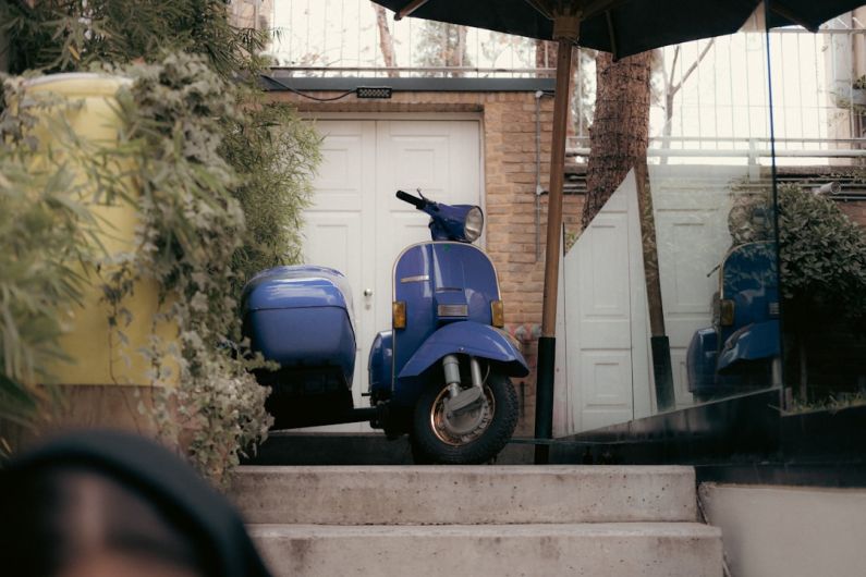 Boutique Hotels - a blue scooter parked in front of a house